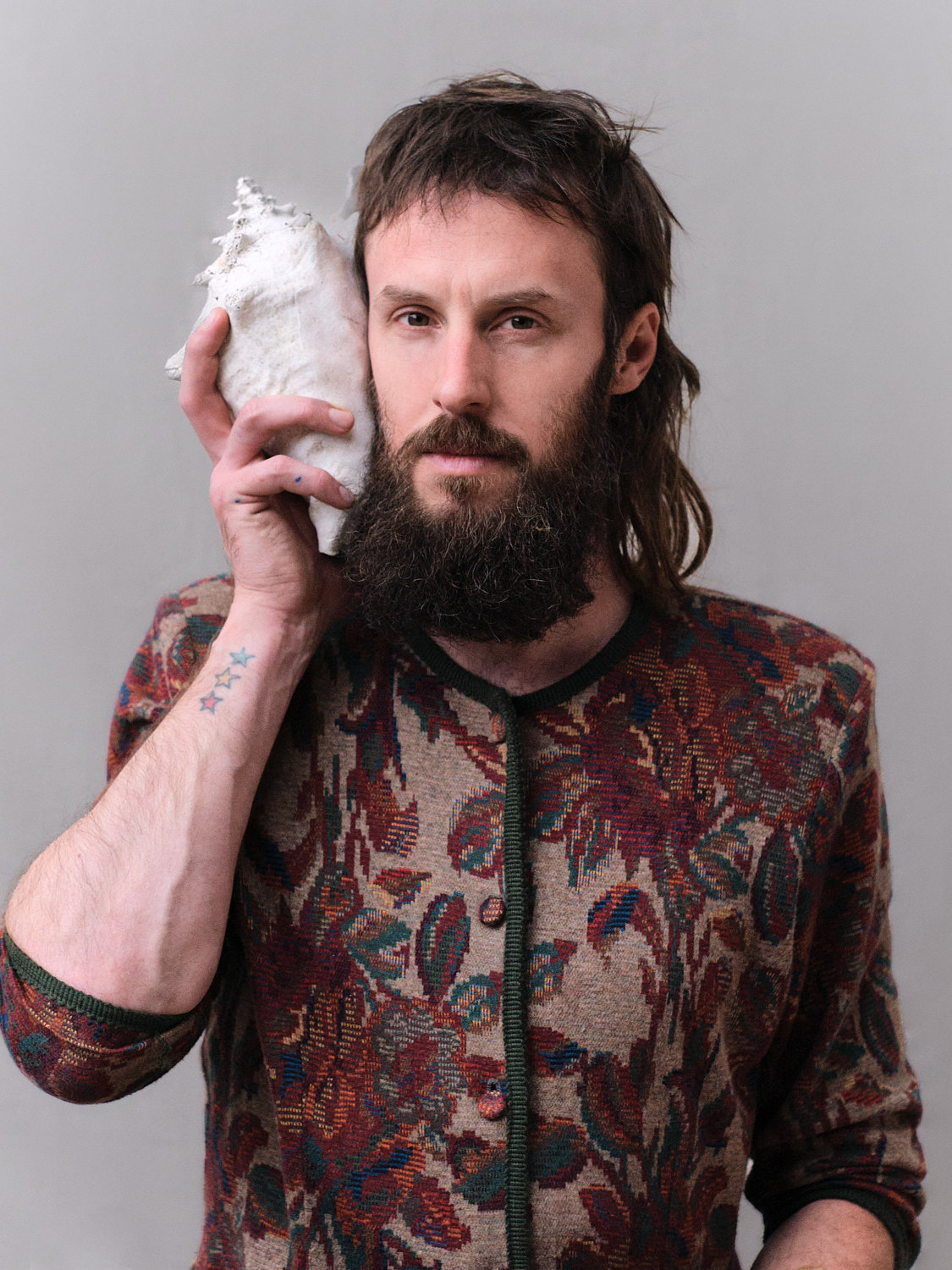 Close-up portrait of artist Thomas Schrenk holding a shell by Vienna- and Berlin-based photographer Sandra Schwaiger – photography by Sandra Schwaiger